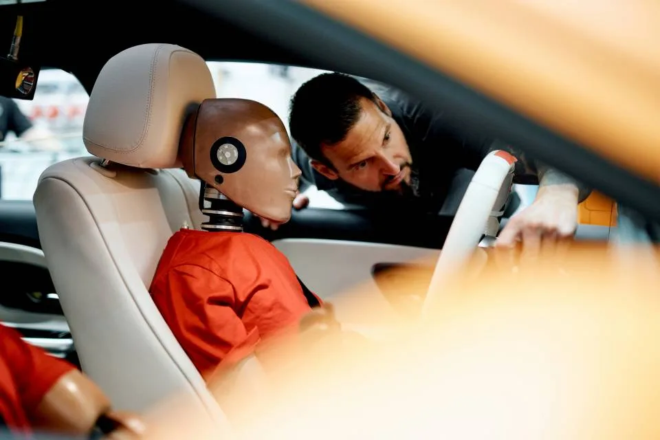 Technician preparing a seated crash-test dummy